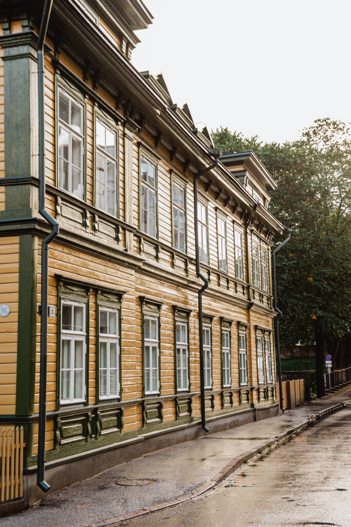 Restaureritud ajalooline puitmaja roheliste aknaraamide ja kollase fassaadiga Kalamajas – Tolira Ehitus töö.