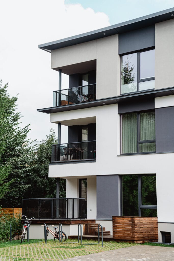 Kivimurru 14 moodne korterelamu, millel on klaaspiiretega rõdud, hallikasvalge fassaad ja haljastatud hoov jalgrattahoidlatega.