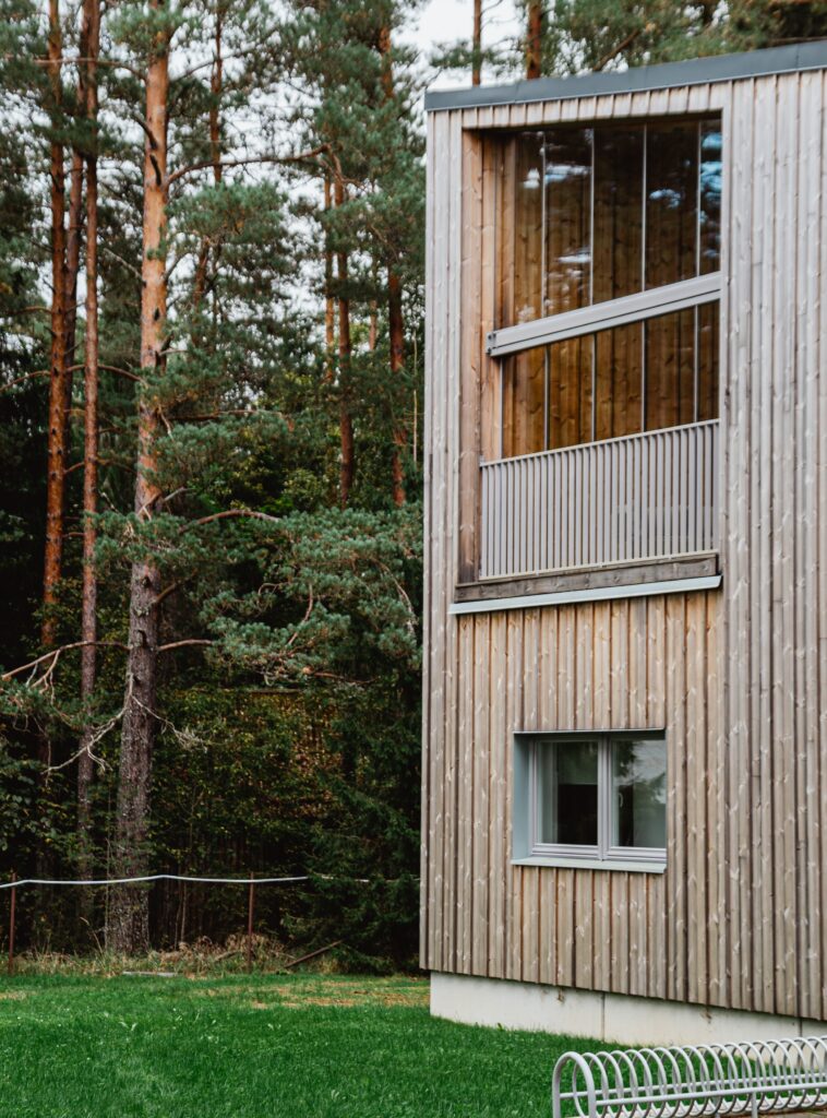 Kaasaegne puidust fassaadiga korterelamu metsa ääres. Energiatõhus elamu looduskeskkonnas.